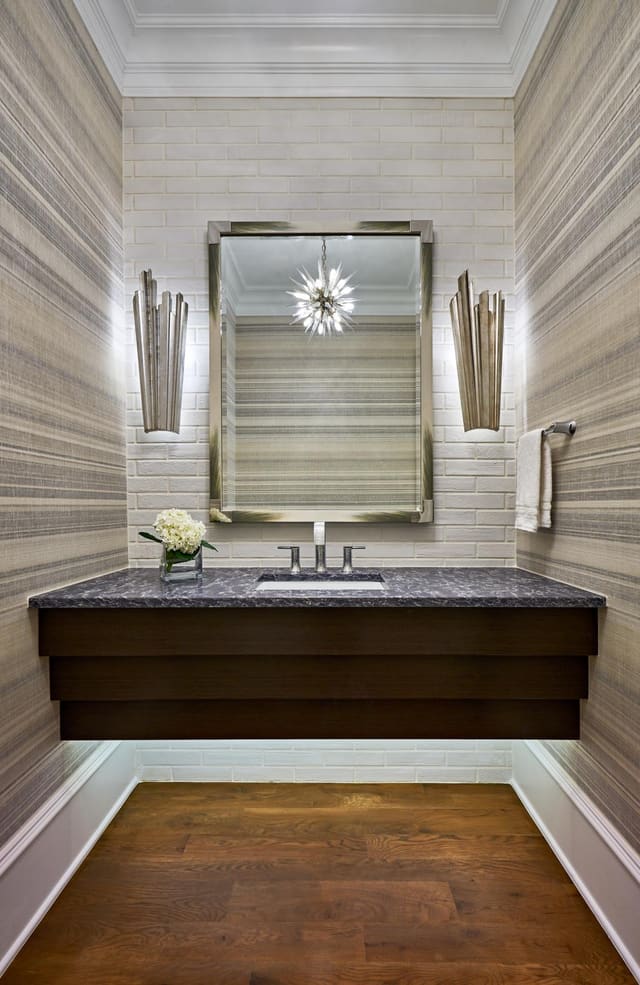 Powder Bath in Wake Forest Home featuring exposed brick wall, wallpaper, floating vanity, and chrome sconces and mirror