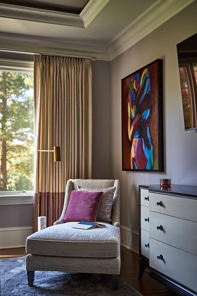 Master Bedroom in Wake Forest home featuring chaise lounge, custom window treatment with purple band, and colorful artwork