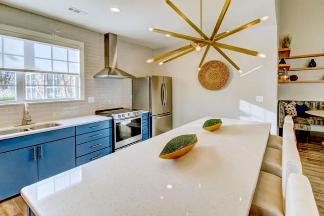 Kitchen area at Indigo Apartments featuring blue cabinets and funky brass light fixture.