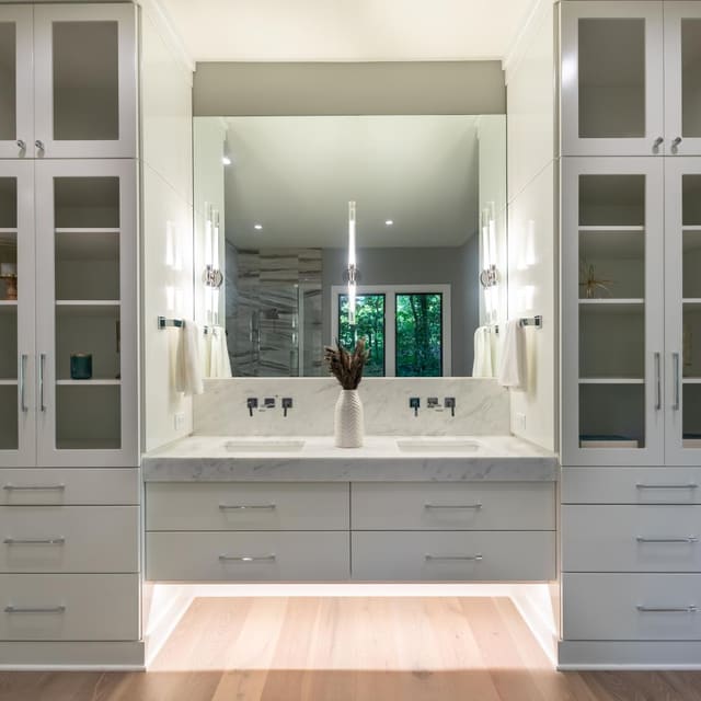 Primary bathroom cabinetry and lighting.
