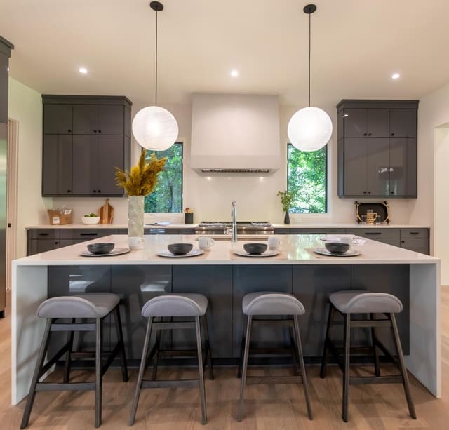 Contemporary kitchen island with four barstools and two globe pendants.