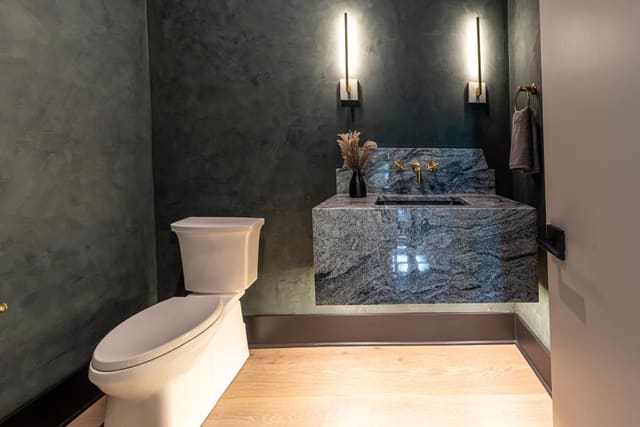 Modody powder bath with dimmed sconce lighting.