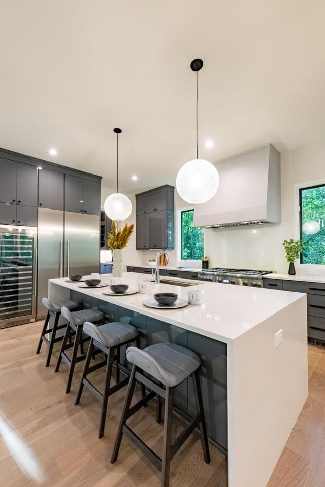 Contemporary marble kitchen island with two globe pendants.