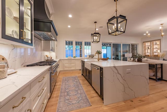 Kitchen of Raleigh home featuring black lantern pendants and waterfall island countertops