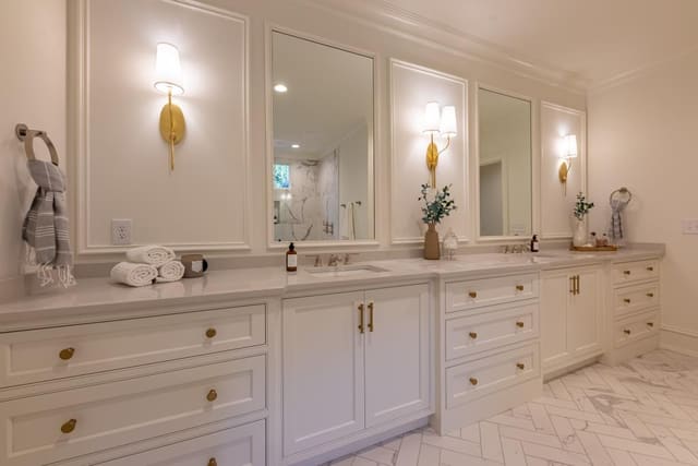 Master Bathroom vanity with white cabinets, gold hardware and gold sconces
