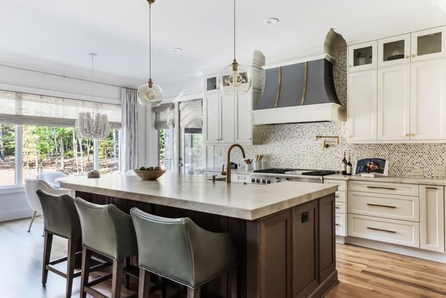 Kitchen and Breakfast Nook of Jordan Lake home featuring custom metal hood and mosaic tile backsplash.