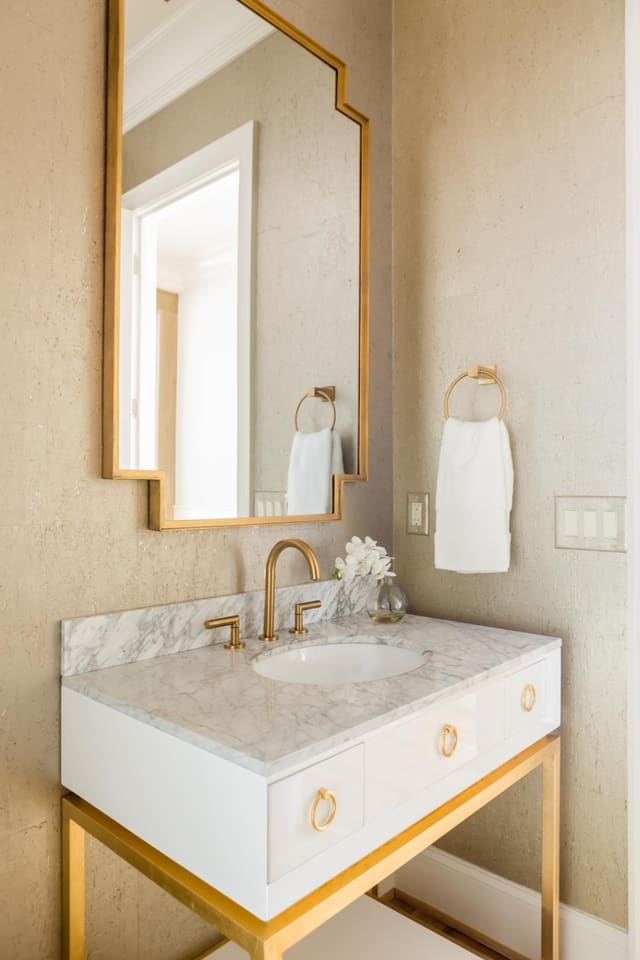 Champagne cork wallpaper brought all the gold details of this Powder Room together.