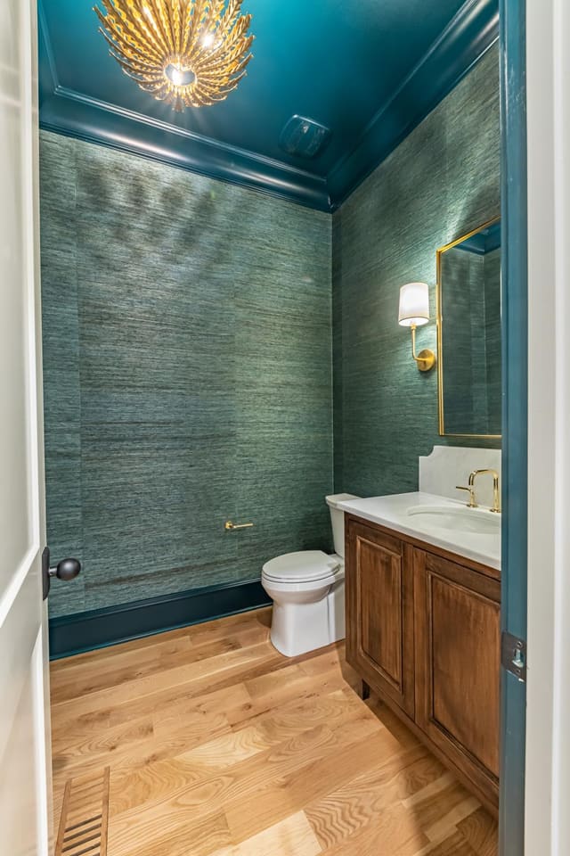 Teal-toned bathroom with textured wallpaper