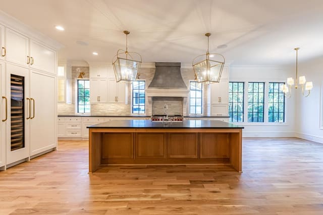 Open concept kitchen with black countertop and brick backsplash