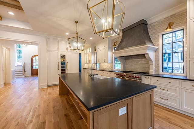 Black countertop island with warm tone cabinetry