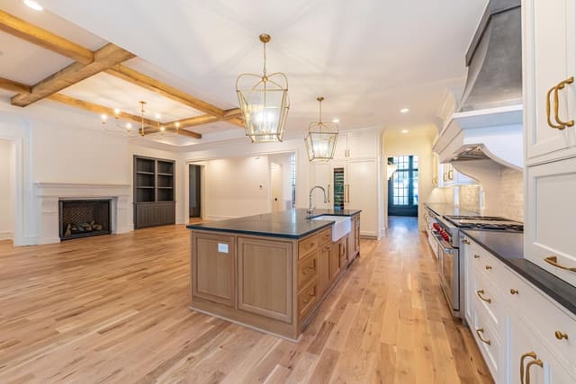 Kitchen open concept into living area with beamed ceilings