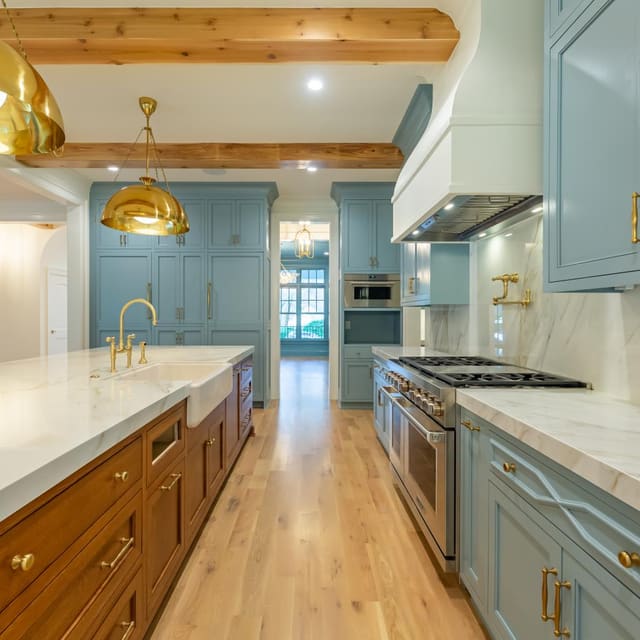 Kitchen with blue cabinetry and gold accents.