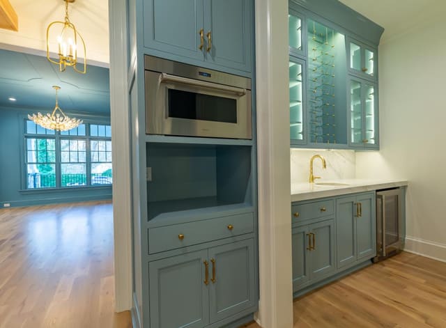 Kitchen with blue cabinetry and gold accents.