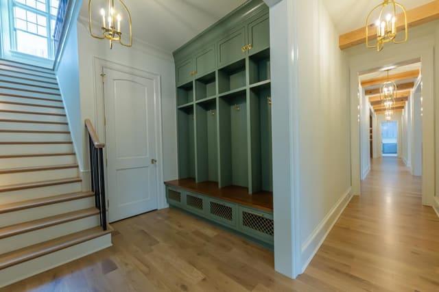 Secondary entryway with teal cabinetry and gold lighting