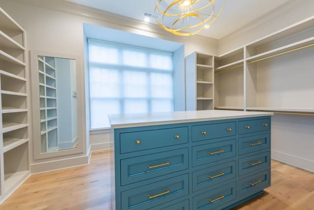 Master Closet with blue dresser and gold accents.