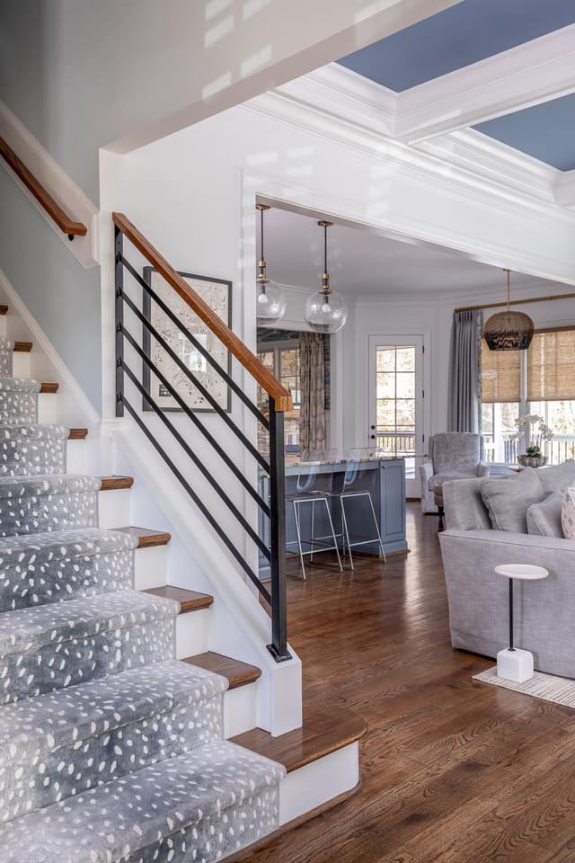 Carpeted staircase leading into open concept living area