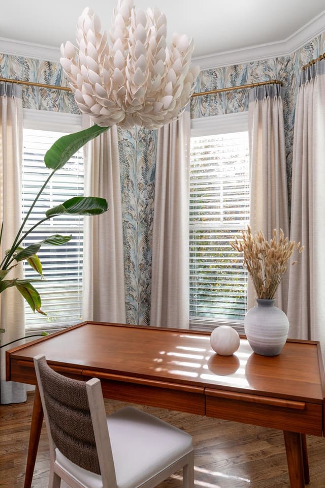 Study with blue toned wallpaper and abstract light fixture