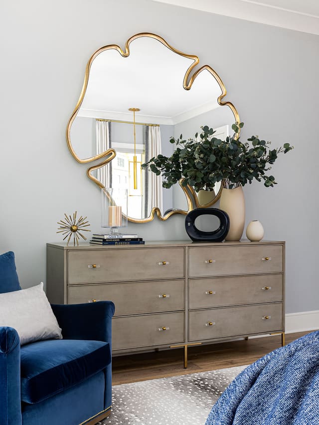 Master bedroom chest with unique flower shaped mirror.