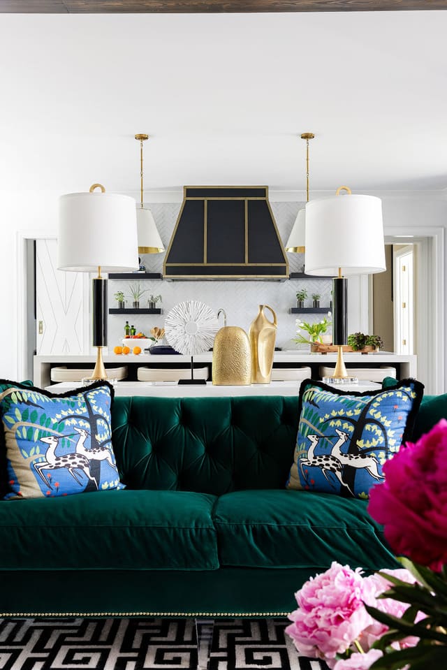Green velvet sofa overlooking kitchen.