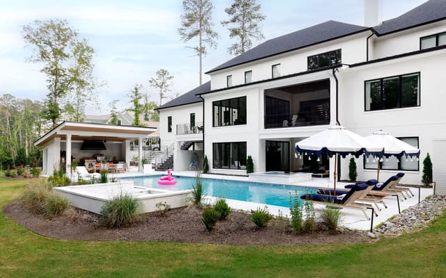 Back exterior of home including pool area.