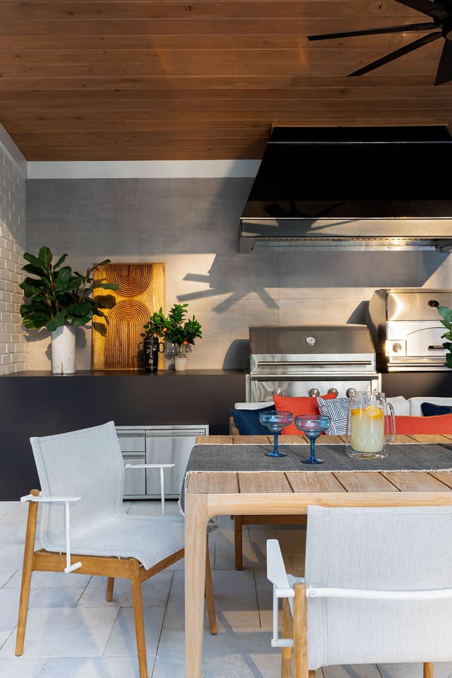 Outdoor grill area including table and chairs.