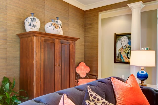Living Room with grasscloth wallpaper, clover back chair, and English Pub Sign