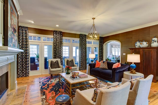 Living Room with custom window treatments, grasscloth wallpaper, colorful area rug, and custom furnishings