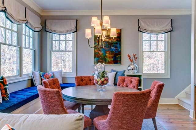 Breakfast Room with upholstered chairs, roman shades, colorful artwork, and window seat cushion
