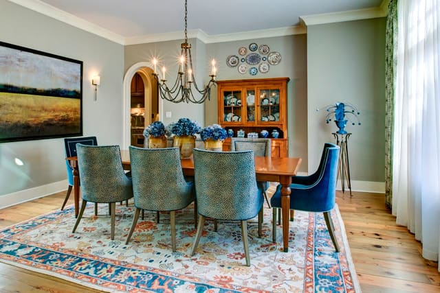 Dining Room with oriental rug and upholstered dining chairs - contrasting captains chairs