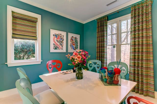 Play Room or Craft Room with turquoise walls, custom window shade and panels, and bright artwork