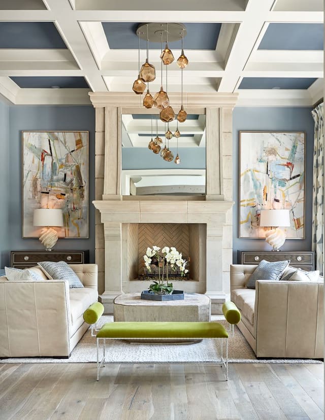 Living Room with rock chandelier, twin leather sofas, contemporary artwork, green velvet bench, coffered ceiling