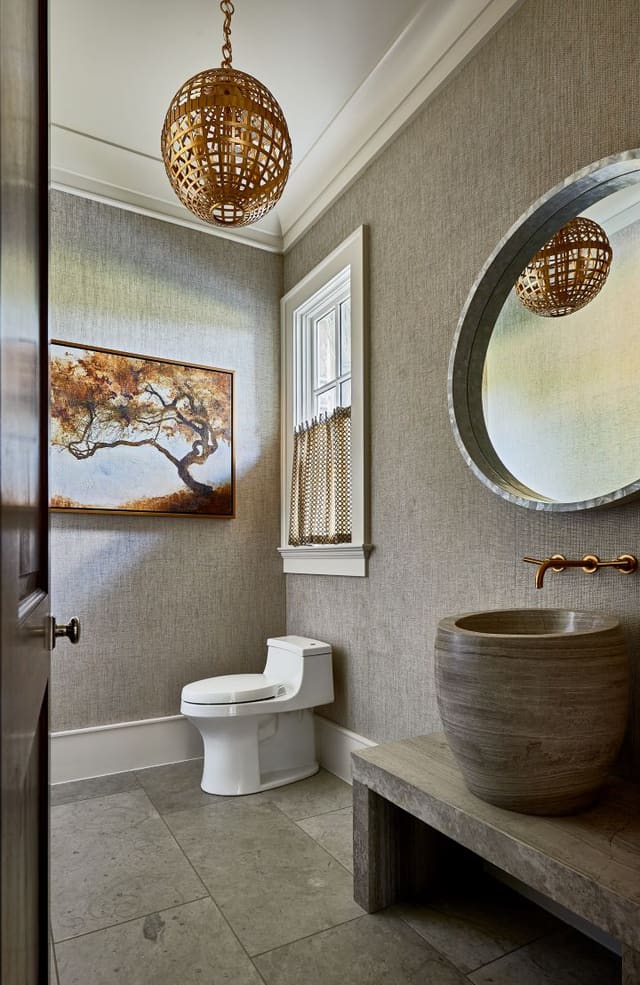 Powder Room with grasscloth wallpaper, gold hanging pendant light, and unique bowl sink.