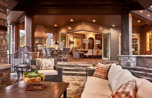Covered porches in Model Home with outdoor Kitchen area opening into dining area with glass sliding walls.