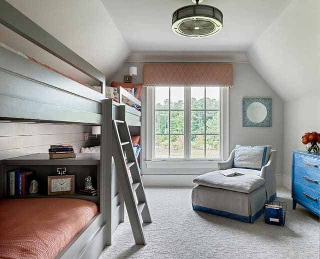 Bedroom with custom built-in bunk beds, window cornice with pom pom trim, chaise lounge, and blue cerused dresser.