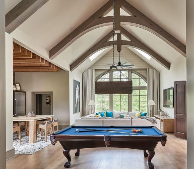 Game Room featuring lofted ceilings with exposed beams, large scale sectional and track style window treatments