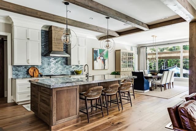 N. Raleigh Kitchen with contrasting island, metal and wood custom hood, clear pendant lighting, and low back counter stools