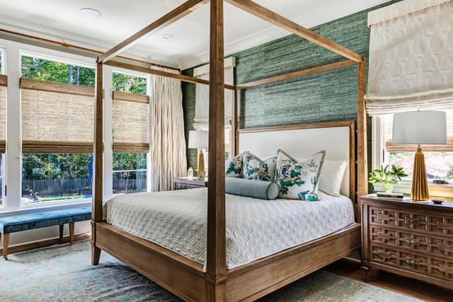 Master Bedroom in N. Raleigh home with green raffia wallpaper, four poster bed with canopy, custom bedding, drapery and roman shades, and woven wood shades.