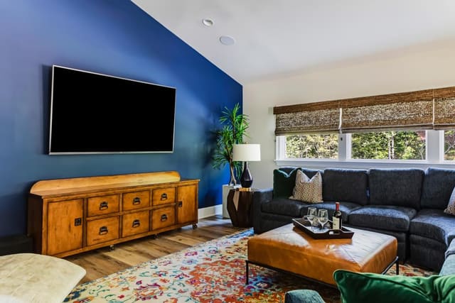 N. Raleigh Game Room with blue accent wall, colorful rug, leather ottomanand blue sectional