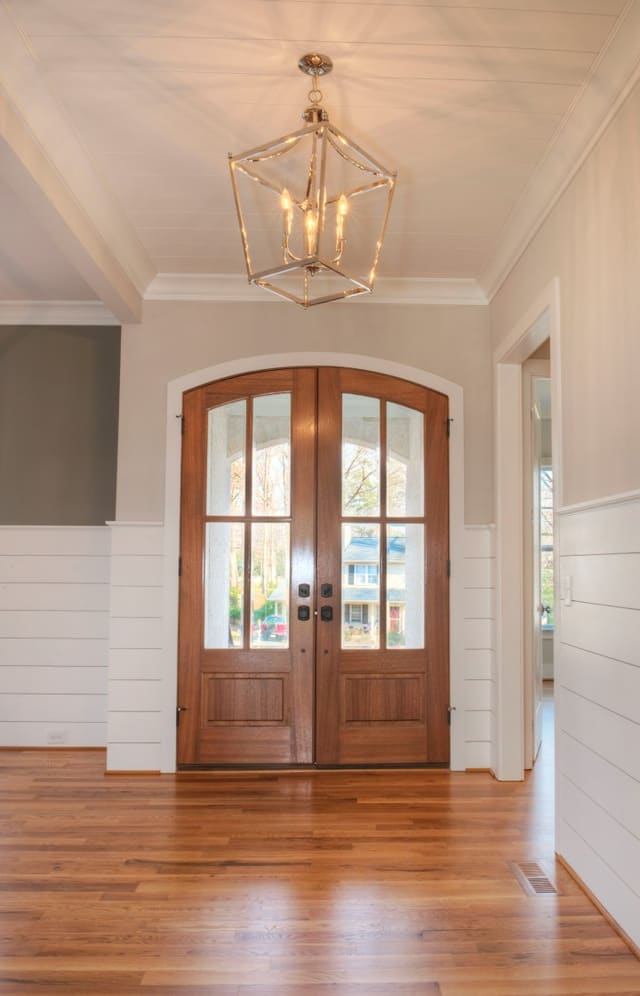 Foyer in North Raleigh home with glass door panes and chrome light fixture.