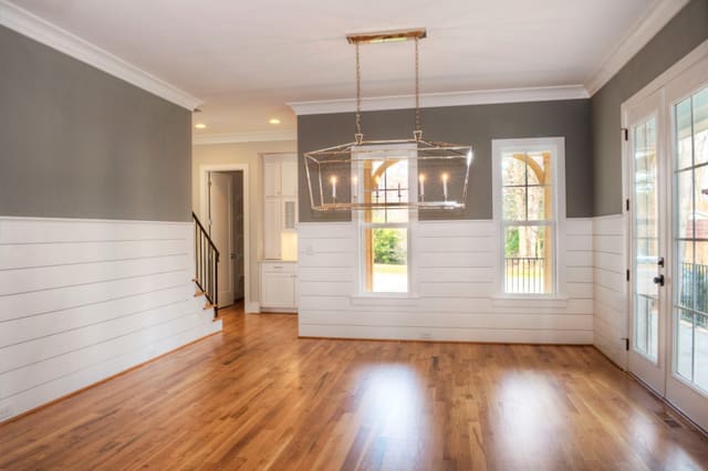 Dining Room with chrome light fixture, gray walls, and wood panelling.