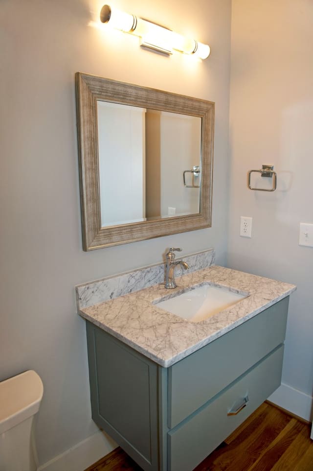 Powder Room with floating painted vanity with marble countertop