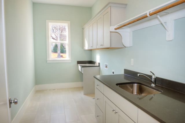 Laundry Room in North Raleigh home with sink, folding area, and built-in cabinets
