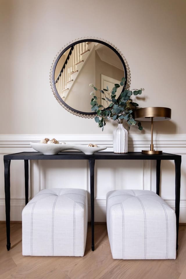 Entryway table with two upholstered stools.