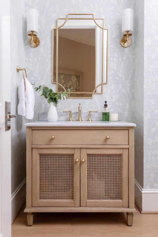 Powder bathroom with gold mirror.