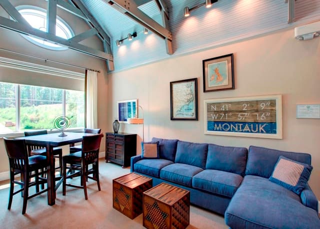 Mezzanine in Raleigh Clubhouse with blue sectional, bar table and chairs, game cube tables, and fun artwork