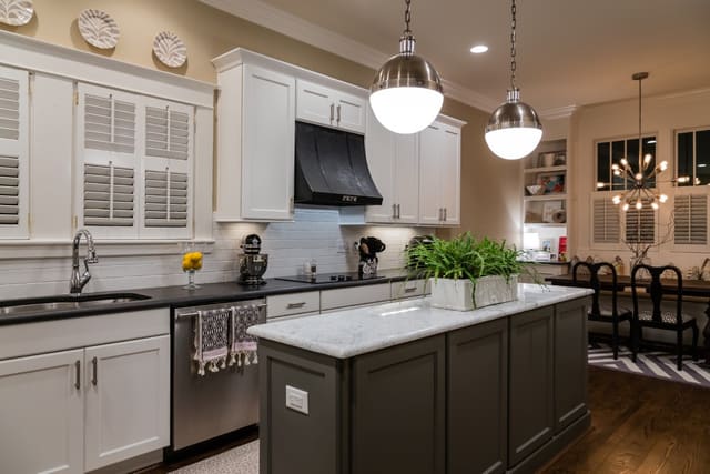 Remodeled Kitchen with white subway tile, white cabinets, contrasting island, and large pendants.