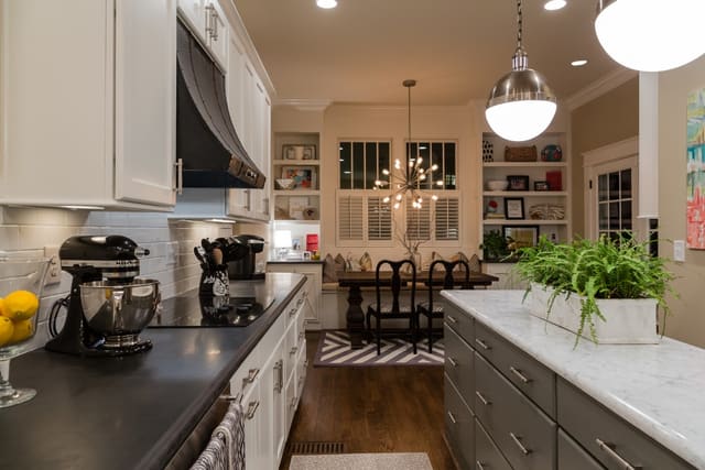 Remodeled Kitchen with white subway tile, white cabinets, contrasting island, and large pendants.