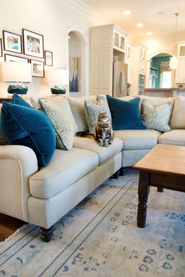Raleigh (ITB) Family Room with wool area rug, custom curved sectional with contrast throw pillows and turquoise lamps