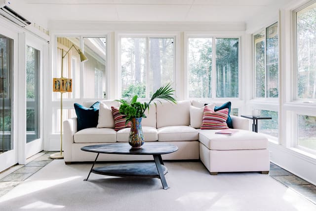 Sun Room with 2-piece neutral sectional with contrast throw pillows.  Coffee table adds a modern flair.