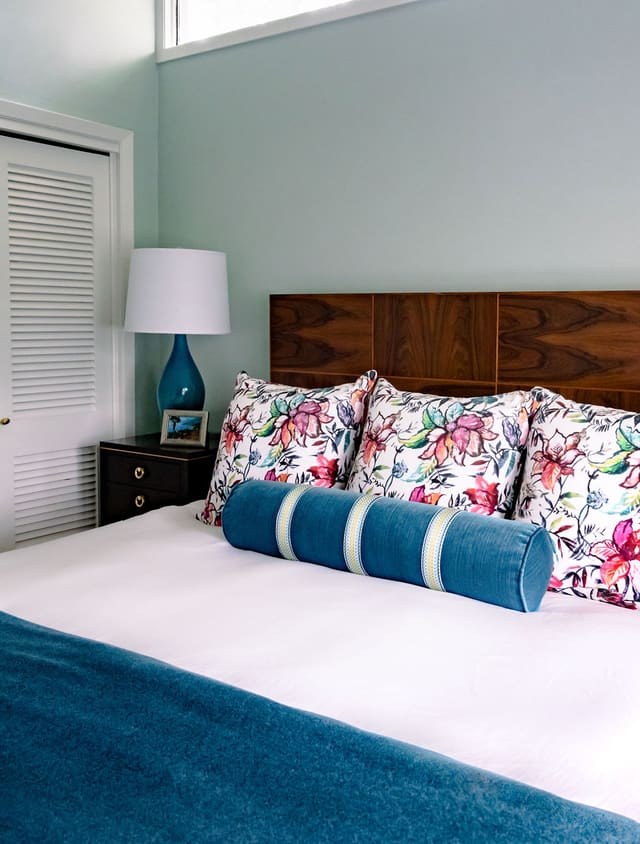 Close up of custom bedding against mahogany headboard.